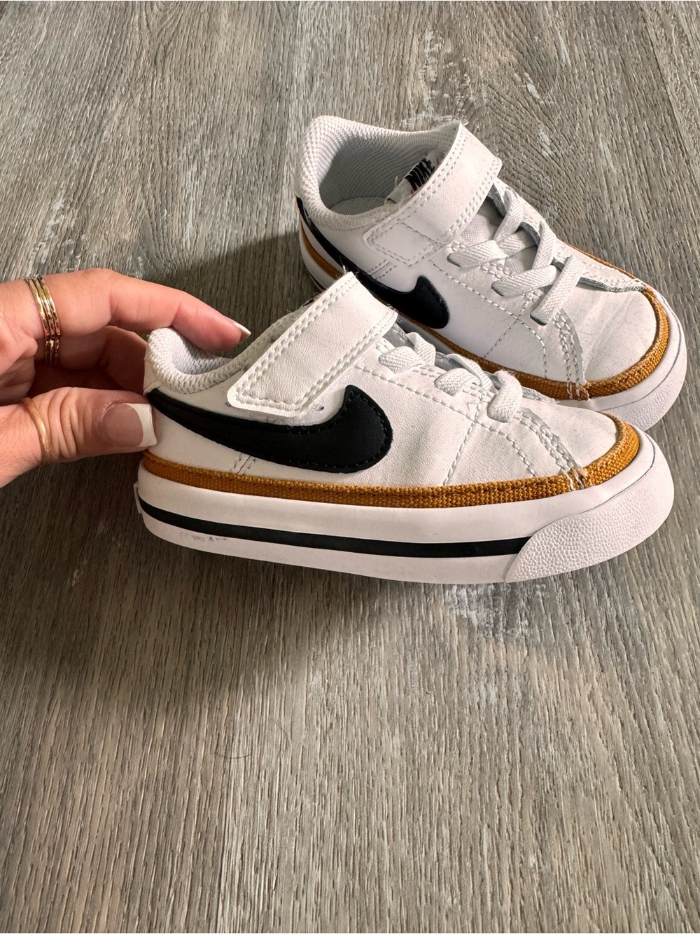 Nike Kids White Sneakers with Black Swoosh and Gold Trim
